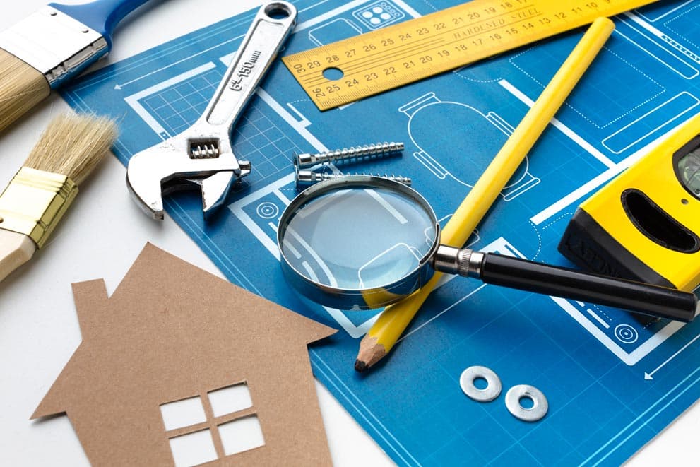 Home improvement tools on a blue background with a house on top